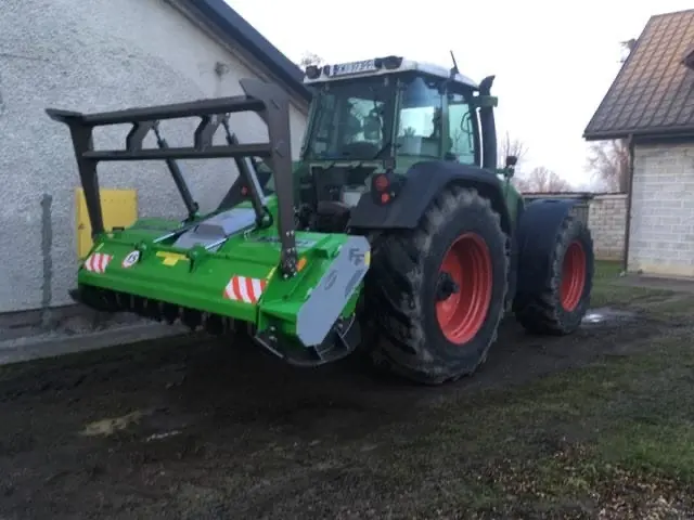 Ciągnik Fendt z mulczerem leśnym przy budynku